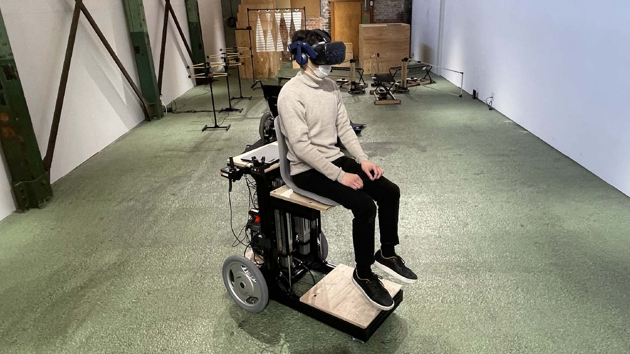 ヘッドマウントディスプレイをつけた人が改造された車椅子に乗っている様子